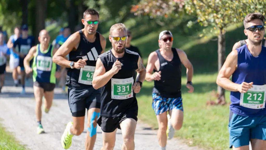 Mehrere Läufer beim Dingolfinger Halbmarathon auf einem Kiesweg.